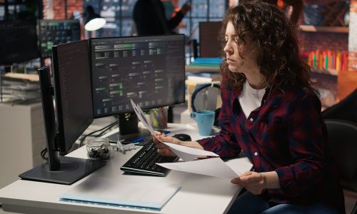 Tech venture business HR employee looking at CVs, doing talent acquisition for potential job applicants. Woman reading resumes of candidates for software development vacant position, camera A